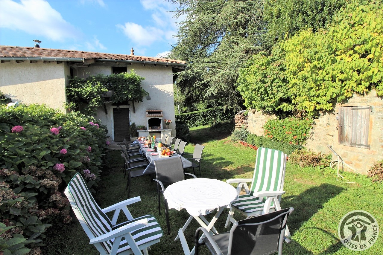 Gîte 'La Glycine' (pour 12 personnes) à Vaux-en-Beaujolais (Rhône - Beaujolais vignobles) : terrain à l'extérieur avec salons de jardin.