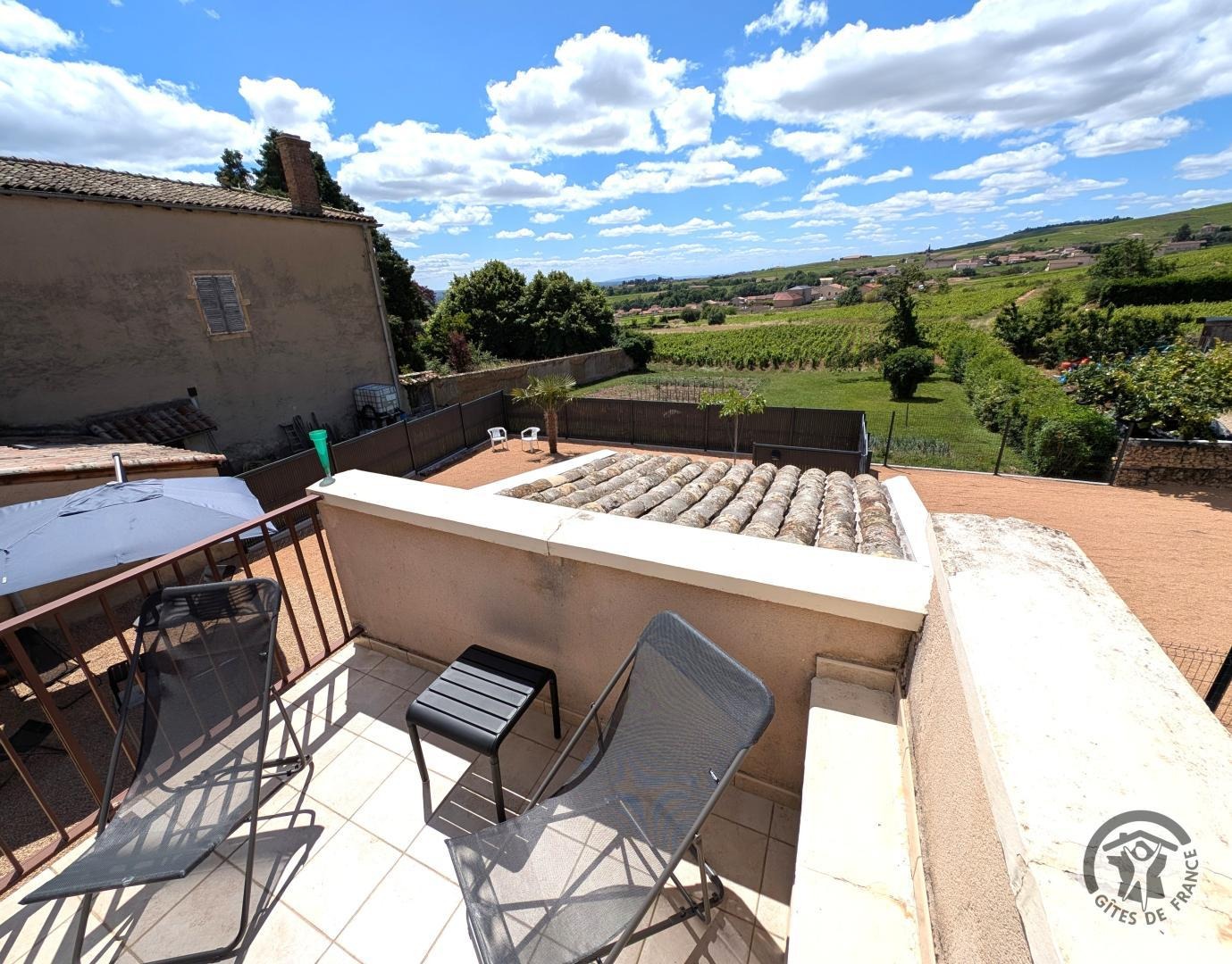 Gîte Le Camélia à Chénas, au coeur des crus du Beaujolais dans le Rhône, proximité Saône et Loire : vue depuis la terrasse sur la cour et les vignes.