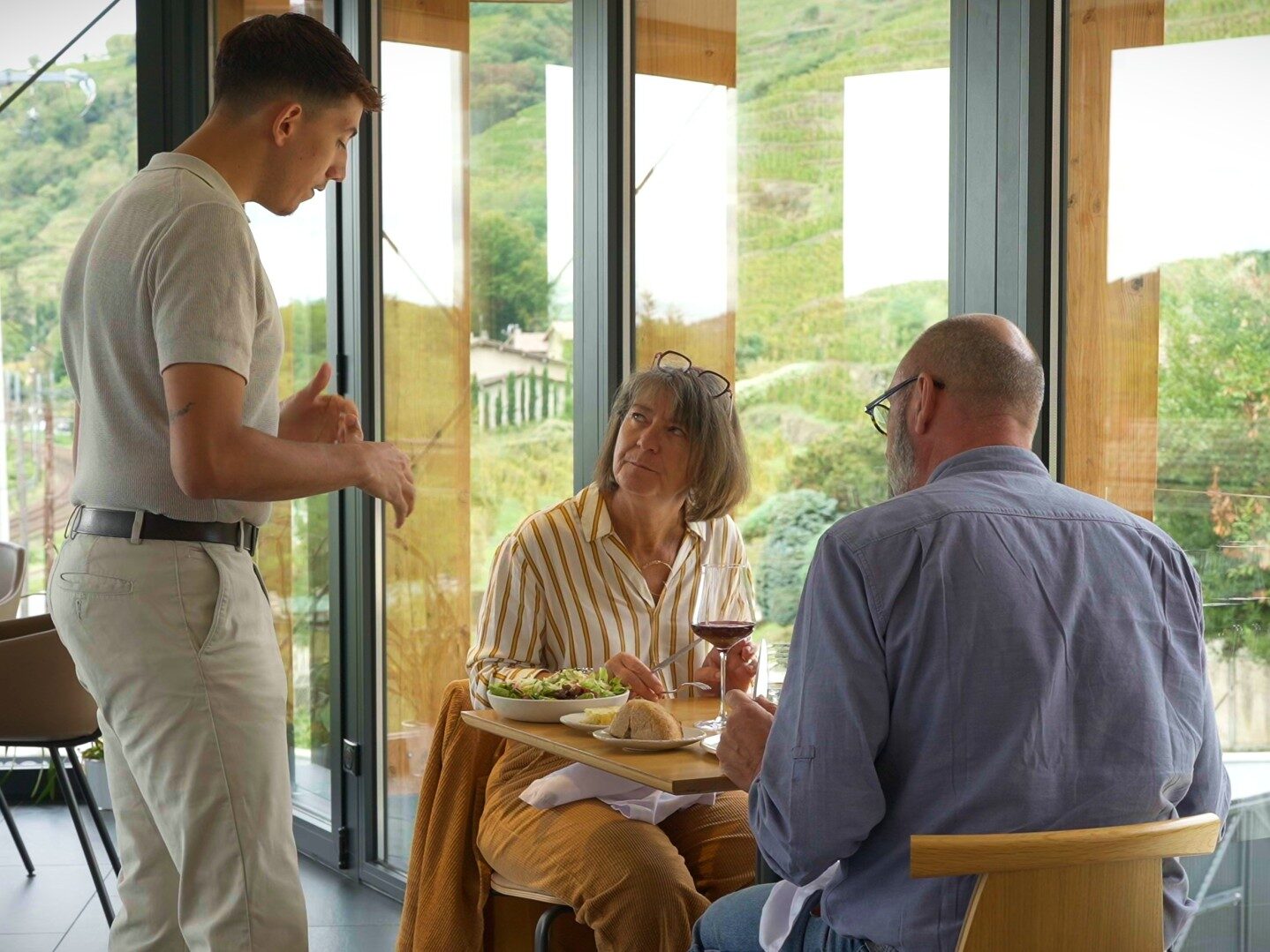 Un couple déjeune dans le restaurant les gagères, un serveur leur demande ce qu'ils veulent manger.