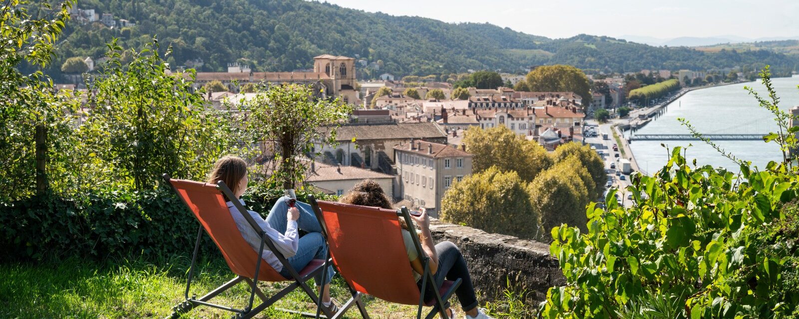 Vienne condrieu tourisme, vue sur le rhône, deux personnes assises sur des transats